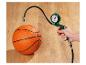 Hand hält ein grünes Luftdruckmessgerät, das mit einem orangefarbenen Basketball verbunden ist.