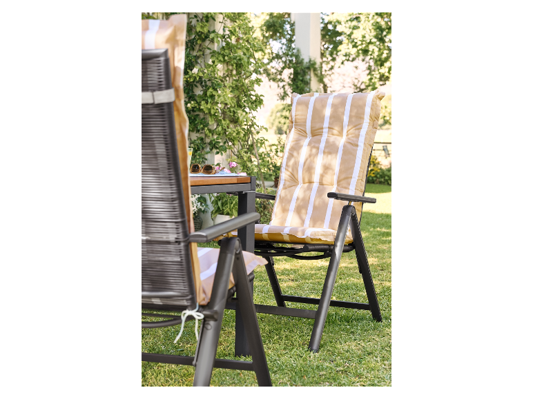 Zwei klappbare Gartenstühle mit gestreiften Kissen auf dem Rasen.