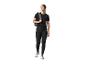 Frau in schwarzen CRIVIT Funktionstights und schwarzem T-Shirt mit Rucksack, blickt zur Seite.