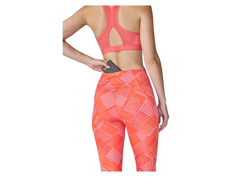 Frau in Sport-BH und Leggings mit Rückentasche, in der sie ein Telefon aufbewahrt.