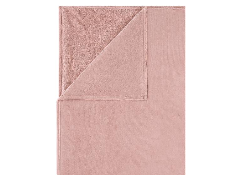 Gefaltete rosa Fleecedecke mit einer glatten und einer strukturierten Seite.