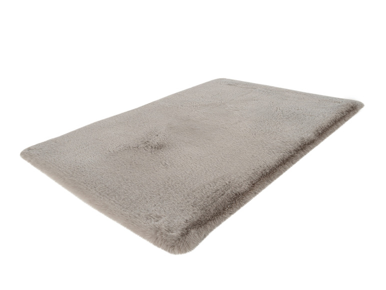 Ein hellgrauer Teppich mit langem Flor.