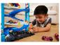 Junge spielt mit einer mehrstufigen Hot Wheels Rennbahn und Autos.