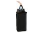 Hand entnimmt eine schwarze Flaschen-Recyclingtasche aus einem schwarzen Wäschekorb.