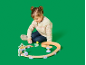 Kind spielt mit einer Holzkugelbahn und einer Kugel mit Hirschmotiv.
