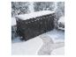 Schwarzer Gartenschuppen mit Schnee auf dem Dach, umgeben von einer Winterlandschaft mit verschneiten Bäumen.