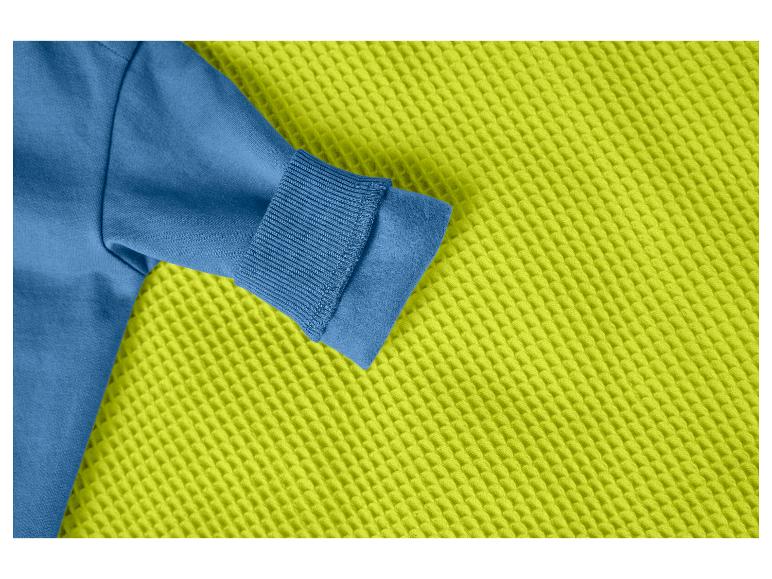 Blauer Sweatshirt-Ärmel auf einem lindgrünen Waffelstoff.