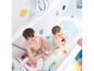 Zwei Kinder im Bad mit Badezeug und einer Badematte mit Meeresmotiven.