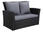 Ein schwarzes Rattan-Sofa mit grauen Kissen