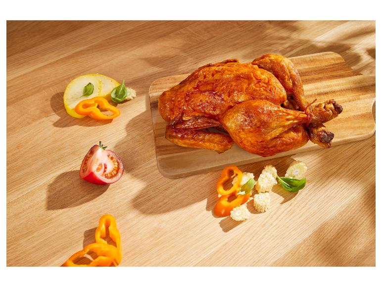 Gebratenes Hähnchen, Gemüse (Paprika, Mais, Tomaten) auf Holzbrett.