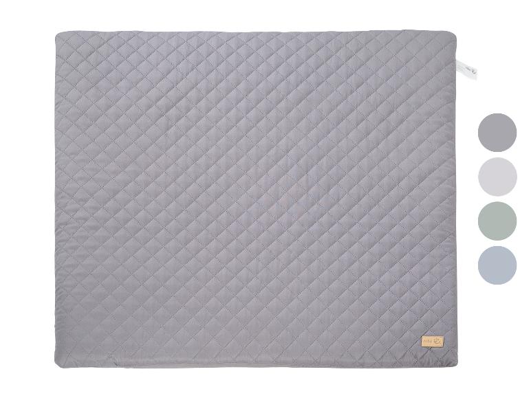 Graue gesteppte Decke mit kleinem Etikett und Farbmustern.