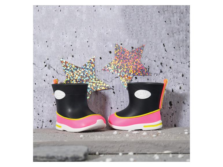 Schwarze und pinke Kinder-Regenstiefel mit gelben Details, mit glitzernden Sternen im Hintergrund.