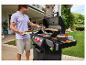 Mann grillt Burger auf einem Gasgrill im Garten.
