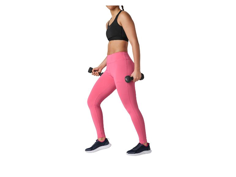 Frau in schwarzem Sport-BH und pinker Leggings mit Hanteln.