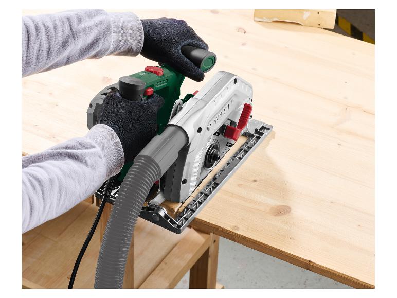 Hände schneiden mit einer Kreissäge mit Staubabsaugschlauch ein Holzbrett.