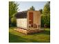 Outdoor-Holzsauna mit Schindeldach, in einem grünen Garten mit Bäumen.