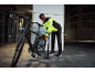 Mann in reflektierender Jacke pumpt nachts einen Fahrradreifen auf.