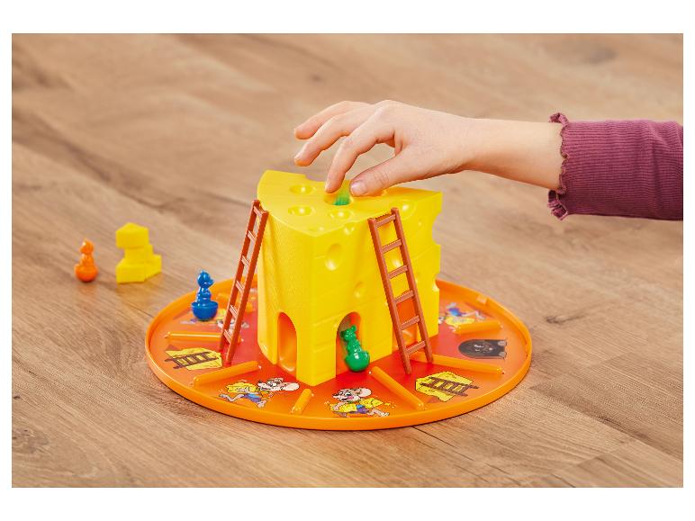 Kinderhand spielt mit einem gelben käseförmigen Brettspiel mit Leitern und Mausfiguren.