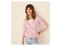 Frau in rosa Wickelpullover und heller Jeans, lächelnd.