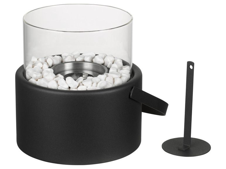 Ein schwarzer Feuerschrank mit Glaswindschutz und dekorativen weißen Steinen.