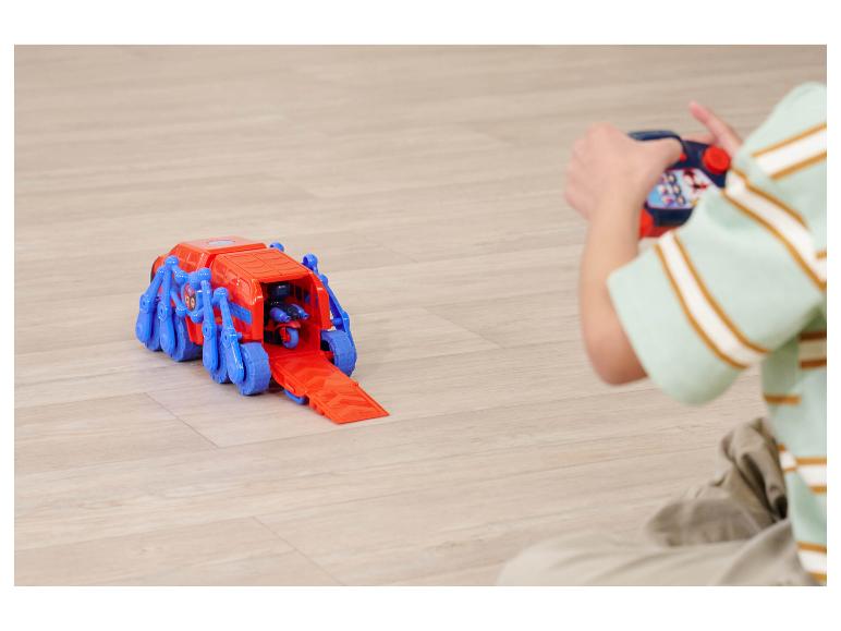 Kind spielt mit einem rot-blauen Spielzeugfahrzeug mit Fernbedienung.