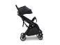 Schwarzer Kinderwagen mit Verdeck und Rädern, von der Seite gesehen.
