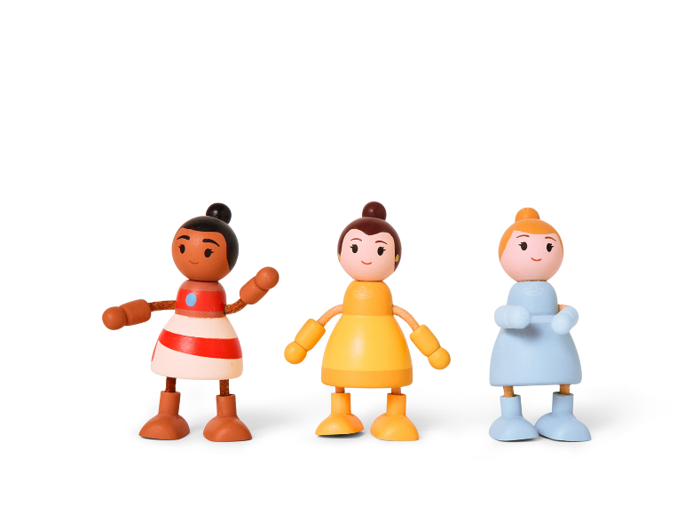 Drei bunte Holzpuppen in verschiedenen Kleidern auf weißem Hintergrund.