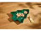 Weihnachtsplätzchen mit festlicher Dekoration auf einem grünen Baumteller.