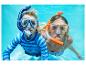 Zwei Kinder schnorcheln unter Wasser, tragen Badeshirts und Bikinis.