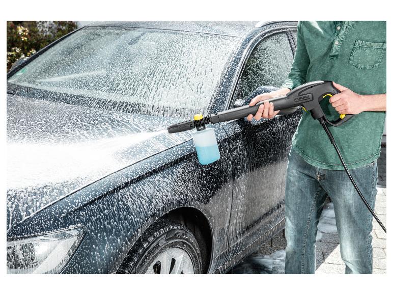 Mann wäscht Auto mit Hochdruckreiniger und Schaumdüse.