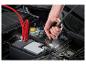 Hand befestigt Überbrückungskabel an Autobatterie.
