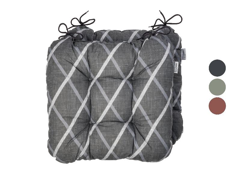 Graues Kissen mit weißem und grauem Karomuster und Bindebändern, mit Farbmustern.