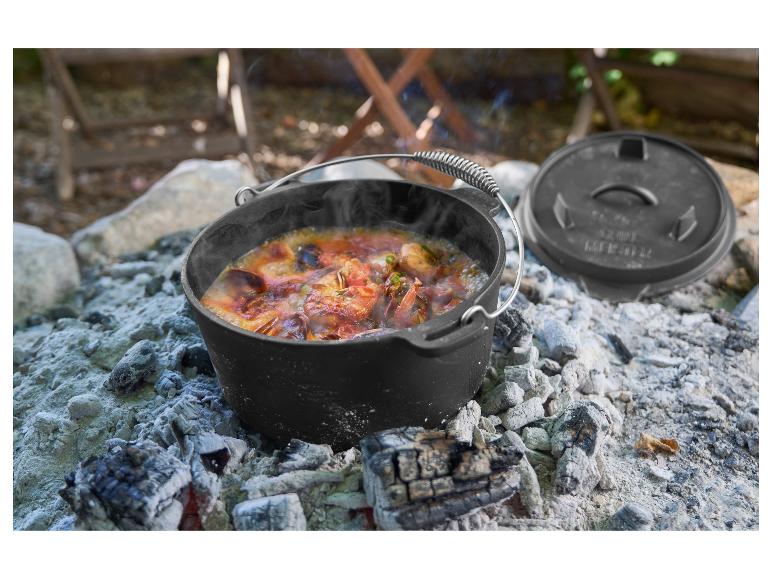 Heißer Topf mit Essen, der draußen auf Kohlen köchelt.