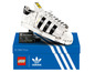 Ein LEGO Modell eines weißen Adidas Superstar Sneakers in der Box.