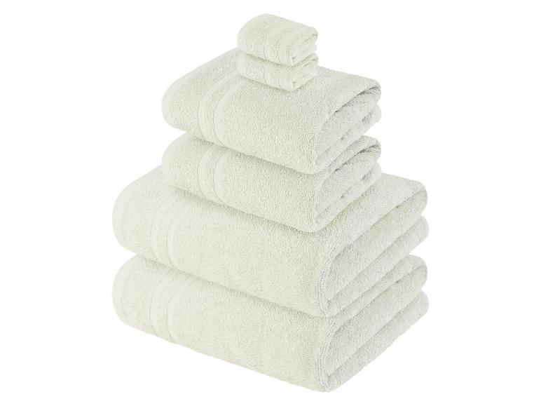 Ein Stapel weicher, cremefarbener Handtücher.