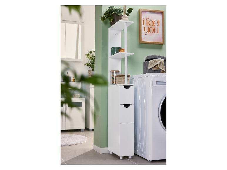 Badezimmer mit Waschmaschine, weißem Schrank mit Schubladen und Regalen und einem gerahmten Bild.