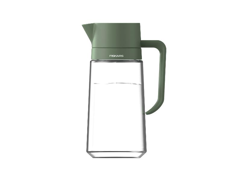 Glaskaraffe mit grünem Deckel und Griff, gefüllt mit Wasser.