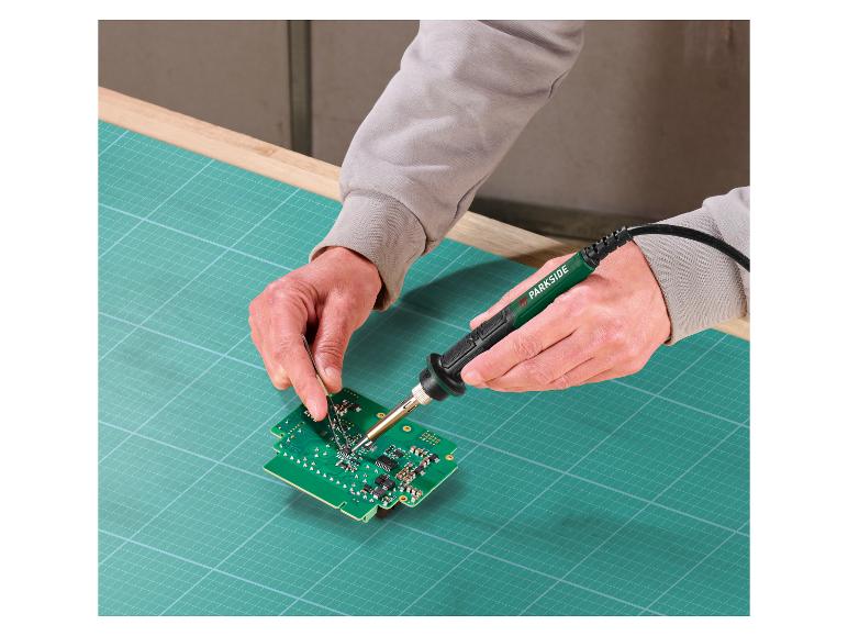 Eine Person benutzt einen Parkside Lötkolben, um an einer Platine zu arbeiten.