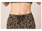 Frau in Leopardenmuster-Hose mit Kordelzug und schwarzem BH.