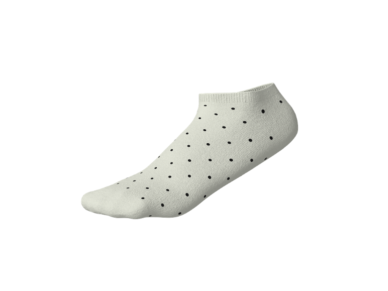 Weiße Sneaker-Socken mit schwarzen Punkten auf schwarzem Hintergrund.