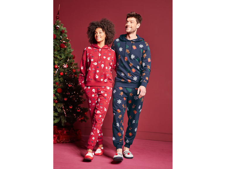 Ein Mann und eine Frau tragen Weihnachtspyjamas mit weihnachtlichen Mustern.