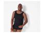 Mann in schwarzem Unterhemd und Boxershorts, lehnt an einer weißen Wand