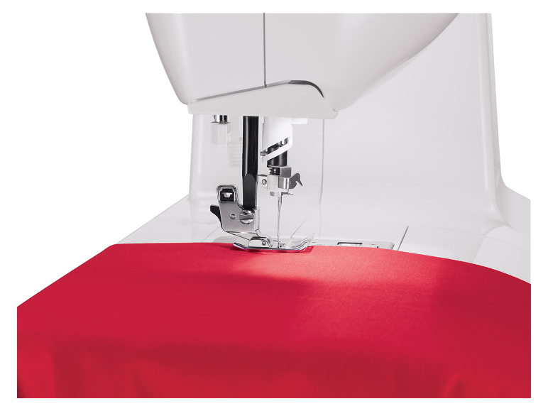 Weiße Nähmaschine näht roten Stoff.