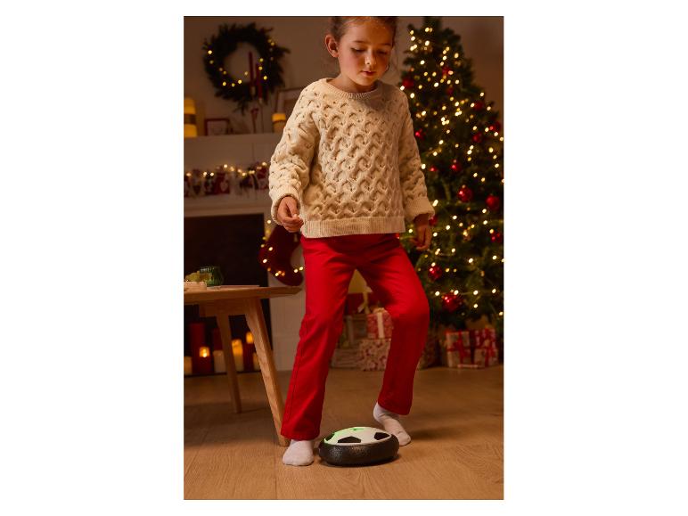 Mädchen spielt Fußball mit einem Hoverball in weihnachtlicher Umgebung.