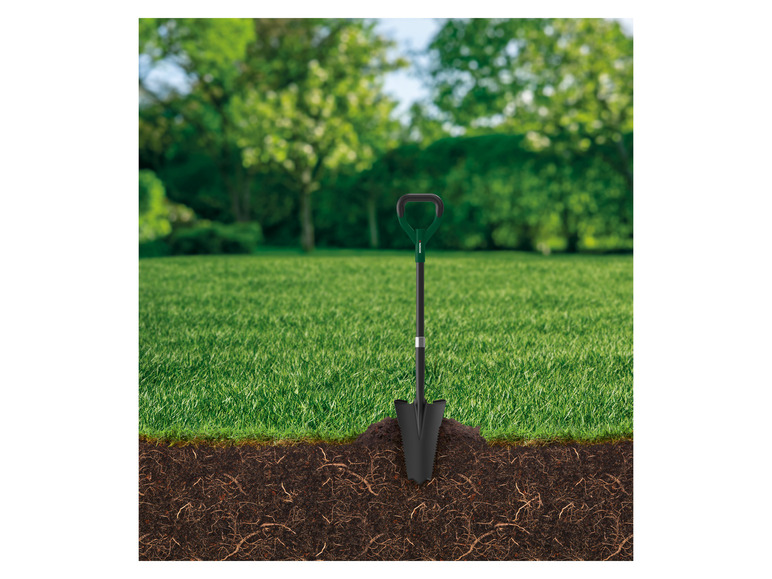 Eine schwarze Schaufel mit grünem Griff in der Erde mit Wurzeln.