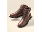 Ein Paar braune Leder-Herrenstiefel mit Schnürsenkeln und dicker Sohle.