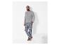 Mann in grauem Langarmshirt und karierter Pyjamahose.