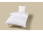Weiße Bettwäschegarnitur mit rosa Herzmuster auf einem Holzbett.