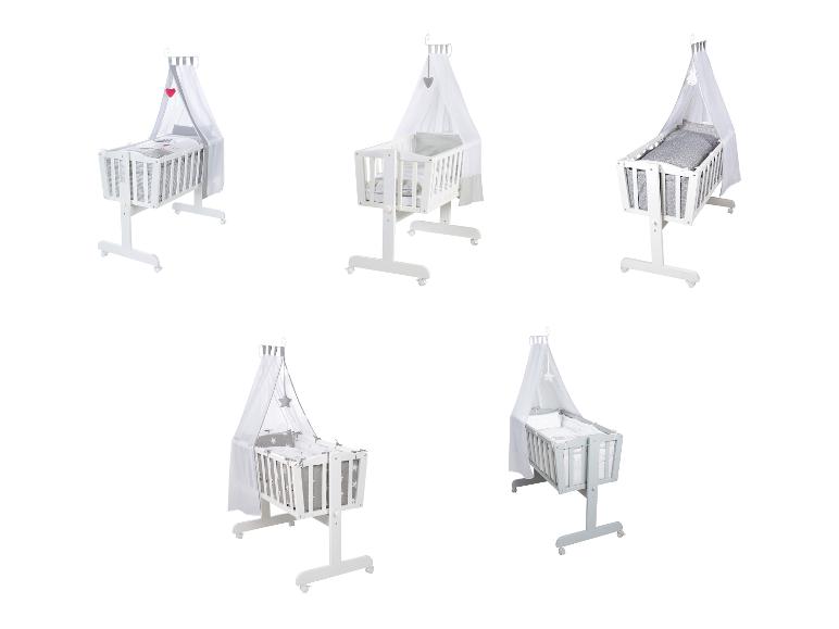 Fünf weiße und graue Babybetten mit Himmel und verschiedenen Bettwäschemustern.