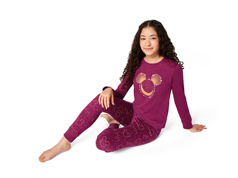 Ein Mädchen trägt einen rosafarbenen Pyjama mit Mickey Mouse-Motiv.